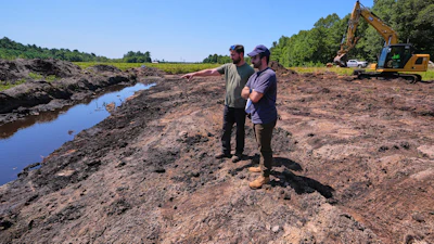 Cranberry grower Jarrod Rhodes points out to engineer Robert Kennedy, right, the path of water flow at a cranberry bog being restored to a natural habitat at the South Meadow Bogs, Thursday, Aug. 7, 2025, in Carver, Mass.