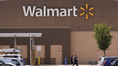 Shoppers walk from the Walmart store, Aug. 14, 2025, in Manchester, N.H.
