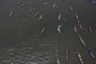 Artisanal fishing boats sit in the water outside the fish landing site in Tanji, Gambia, on March 25, 2025.