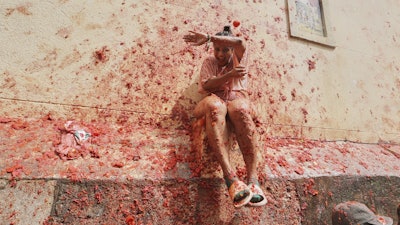 Revelers throw tomatoes at each other during the annual 'Tomatina' tomato fight fiesta, in the village of Bunol near Valencia, Spain, Wednesday, Aug. 27, 2025.
