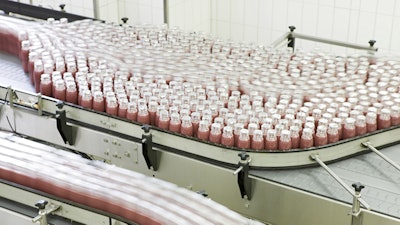 Bottling conveyor line with rows of glass bottles.