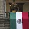 A Mexican flag hangs at the National Palace, where a portrait of former Mexico President Andres Manuel Lopez Obrador hangs, as President Claudia Sheinbaum delivers her first state-of-the-nation address in Mexico City, Monday, Sept. 1, 2025.