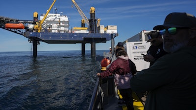 Expedition 501 members look down from the Liftboat Robert platform, to the approaching Gaspee, a crew transport vessel, in the North Atlantic, Saturday, July 19, 2025.