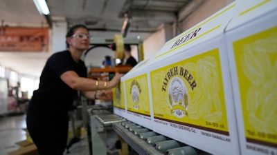 Nadin Khoury, 36, packs Taybeh beer products on a production line of the family's Taybeh Brewery Co. in the West Bank town of Taybeh, Sept. 6, 2025.