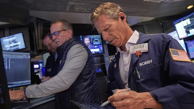 Trader Robert Charmak, right, and specialist Glenn Carell, center, work on the floor of the New York Stock Exchange, Sept. 10, 2025.