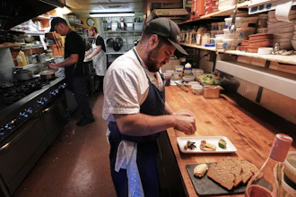 Chef Jake Vatalaro sprinkles locally foraged locust flower seasoning on a Chef's Meze Plate, which includes locally foraged mushrooms, at the Black Trumpet restaurant, Tuesday, Sept. 16, 2025, in Portsmouth, N.H.