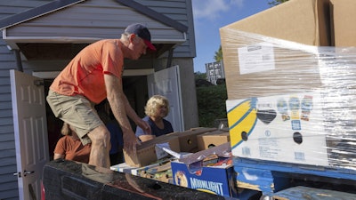Neighbors Cupboard volunteers Mike Masnyk and Ellie Jordan unload the morning delivery of produce in Winterport, Maine, Aug. 26, 2025.