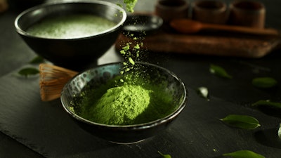 Matcha powder being added to a bowl.