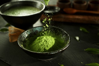 Matcha powder being added to a bowl.