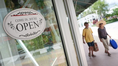 Shoppers walk by a clothing store, Sept. 25, 2025, Miami Beach, Fla.
