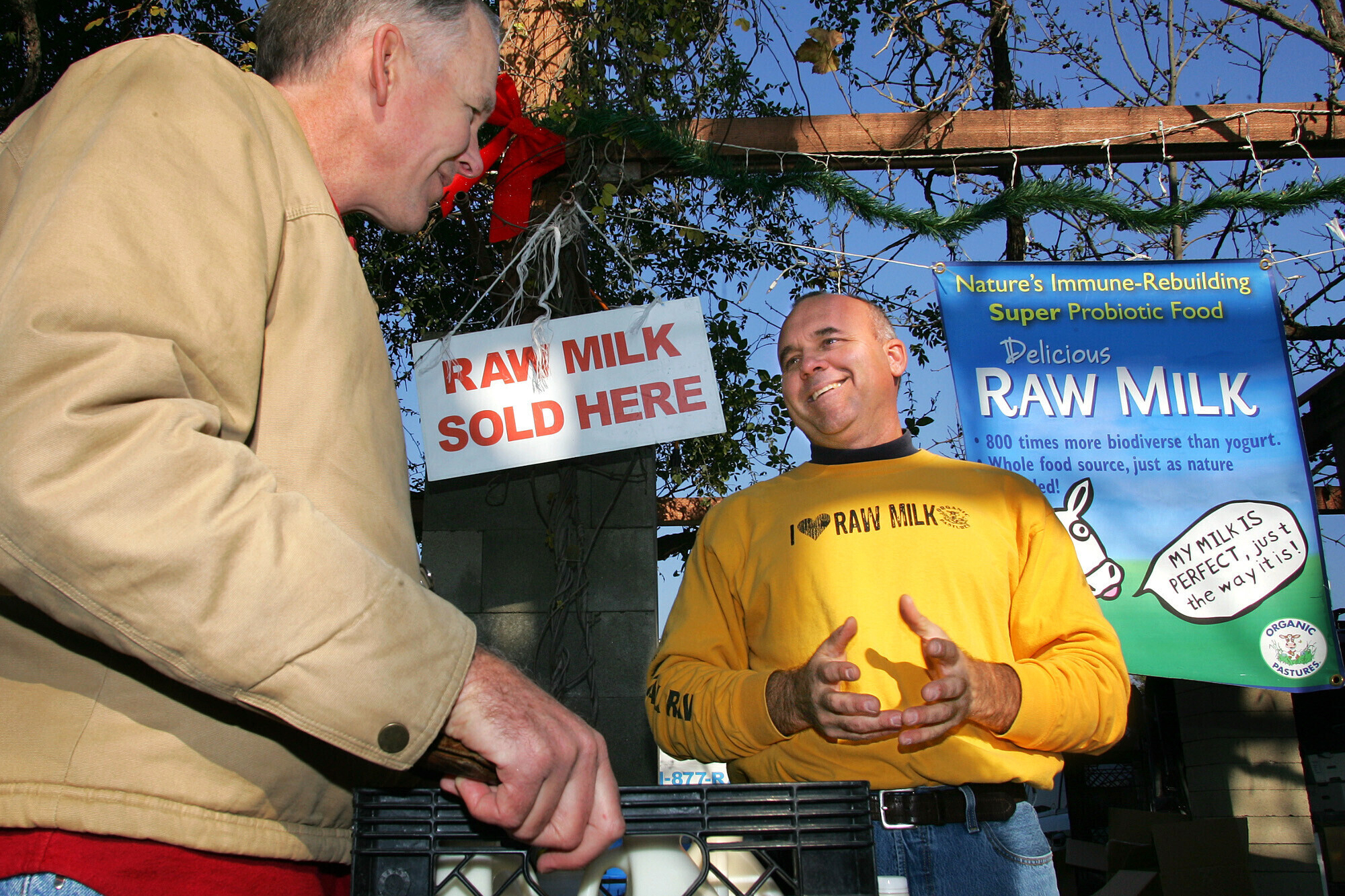 Veterinarian Patrick Smith, left, discusses raw milk with dairyman and producer Mark McAfee at the Farmer's Market in Fresno, Calif., on Dec. 22, 2007.