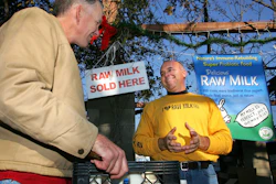 Veterinarian Patrick Smith, left, discusses raw milk with dairyman and producer Mark McAfee at the Farmer's Market in Fresno, Calif., on Dec. 22, 2007.