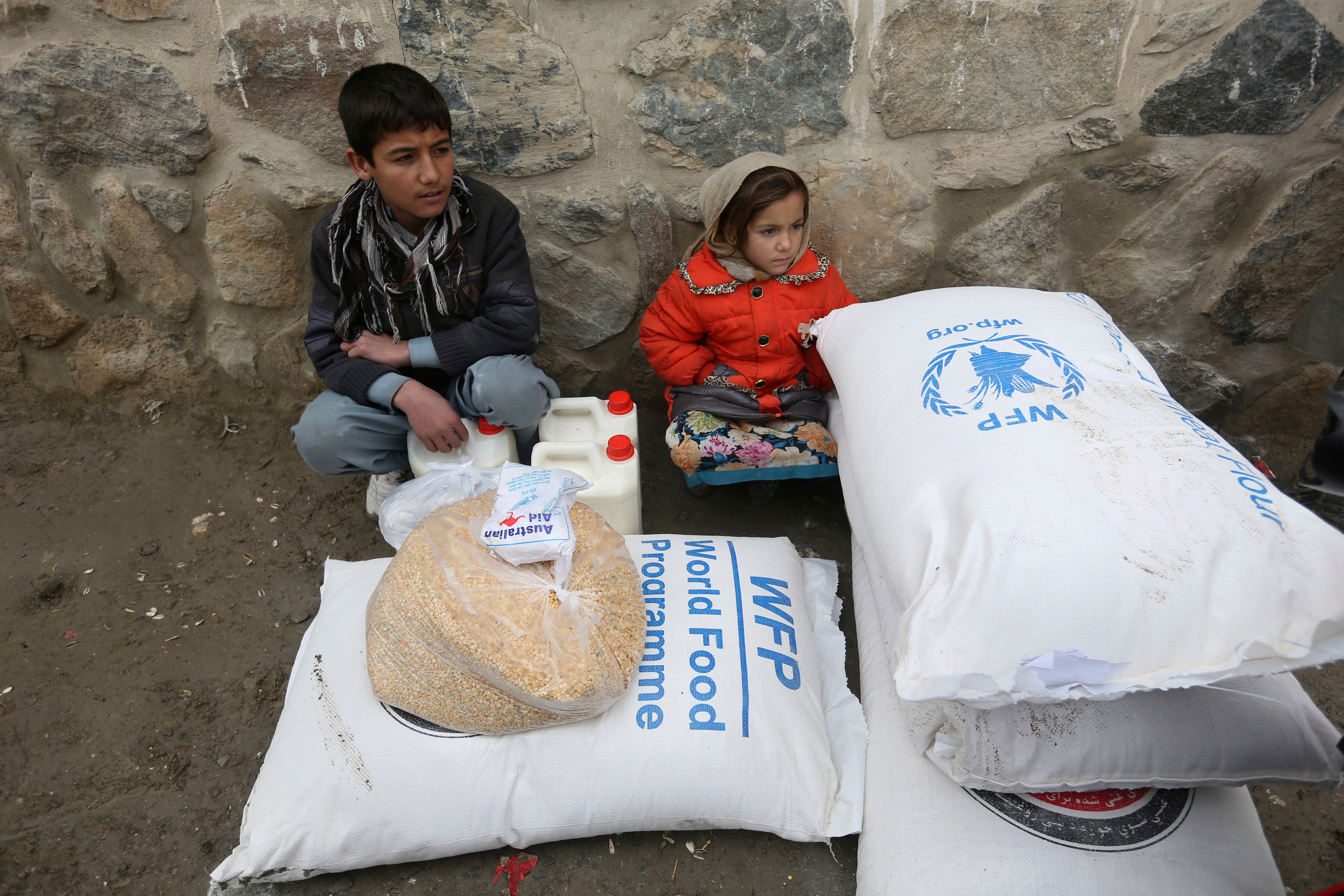 Children wait for transportation after receiving food donated by the World Food Program, in Kabul, Afghanistan, Jan. 24, 2017.