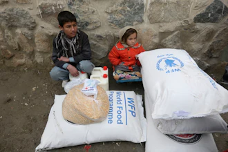 Children wait for transportation after receiving food donated by the World Food Program, in Kabul, Afghanistan, Jan. 24, 2017.