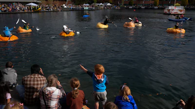 A child points to people racing giant pumpkins during the West Coast Giant Pumpkin Regatta on Sunday, Oct. 19, 2025, in Tualatin, Ore.