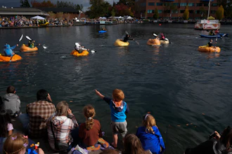 A child points to people racing giant pumpkins during the West Coast Giant Pumpkin Regatta on Sunday, Oct. 19, 2025, in Tualatin, Ore.