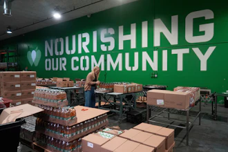 Mara Sleeter, marketing and communications project manager, stands near boxes of juice while being interviewed in the San Francisco-Marin Food Bank warehouse in San Francisco, July 2, 2025.