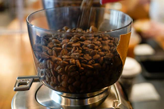Coffee beans are poured into a grinder at a cafe in College Park, Md., on Wednesday, Sept. 1, 2021.