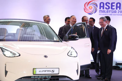 Chinese Premier Li Qiang, right, reacts as he, along with Malaysian Prime Minister Anwar Ibrahim, center, inspects a car produced by Malaysia's national automaker, Proton, in which China's Zhejiang Geely Holding Group holds a 49.9% stake, ahead of the signing ceremony for the ASEAN&ndash;China Free Trade Area 3.0 Upgrade and the ASEAN&ndash;China summit, held as part of the ASEAN summit in Kuala Lumpur, Malaysia Tuesday, Oct. 28, 2025.