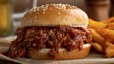Barbecue pulled pork sandwich with a sesame bun.