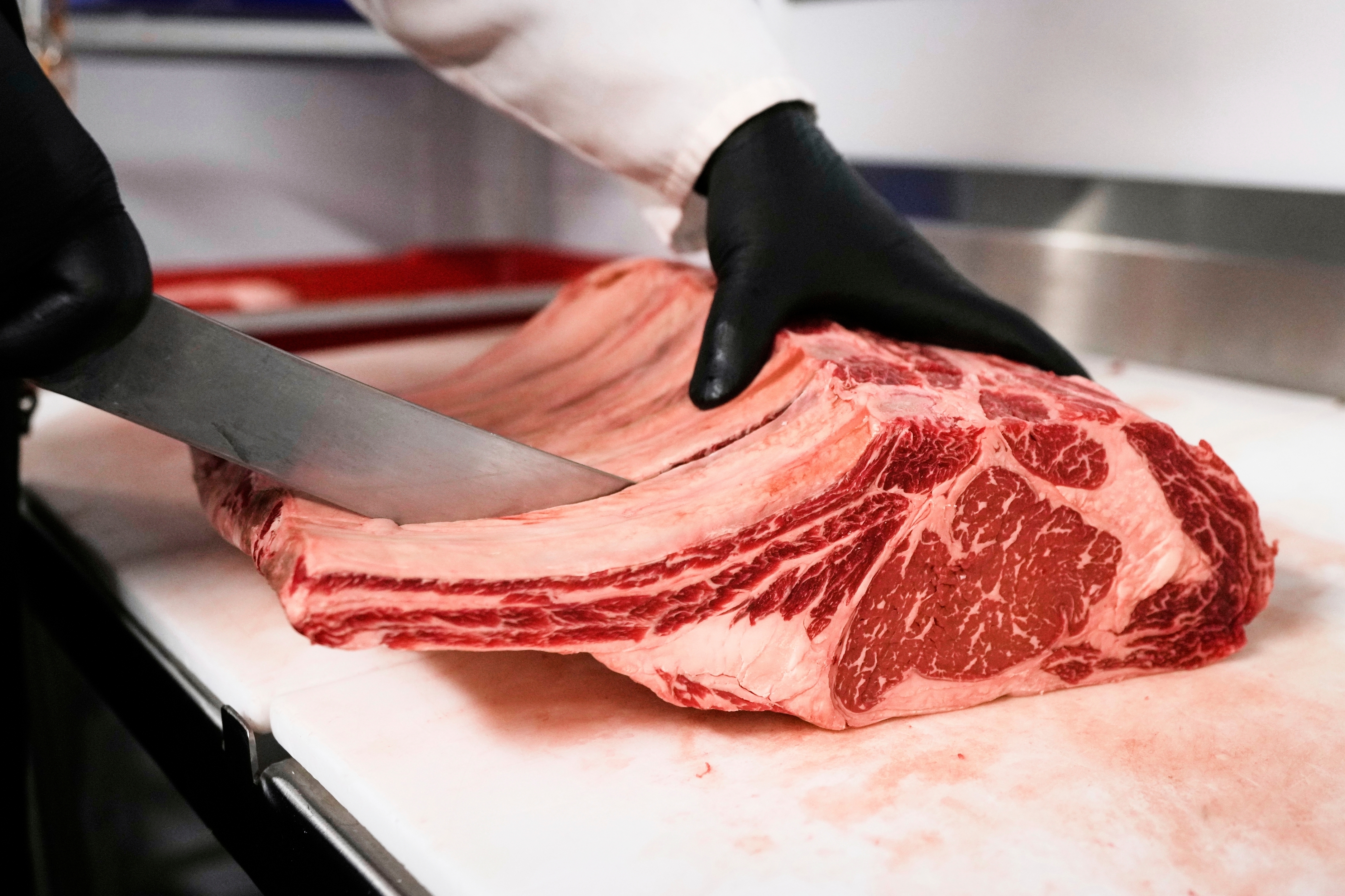 Raul Rubero, lead butcher at Deep Cuts butcher shop cuts single portions of bone-in steaks as he breaks down a side of beef, Wednesday, Aug. 27, 2025, in Dallas.