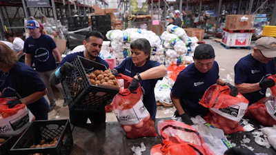 Volunteers at the San Antonio Food Bank load bags of potatoes for a food distribution for SNAP recipients and other households affected by the federal shutdown, Thursday, Nov. 6, 2025, in San Antonio.