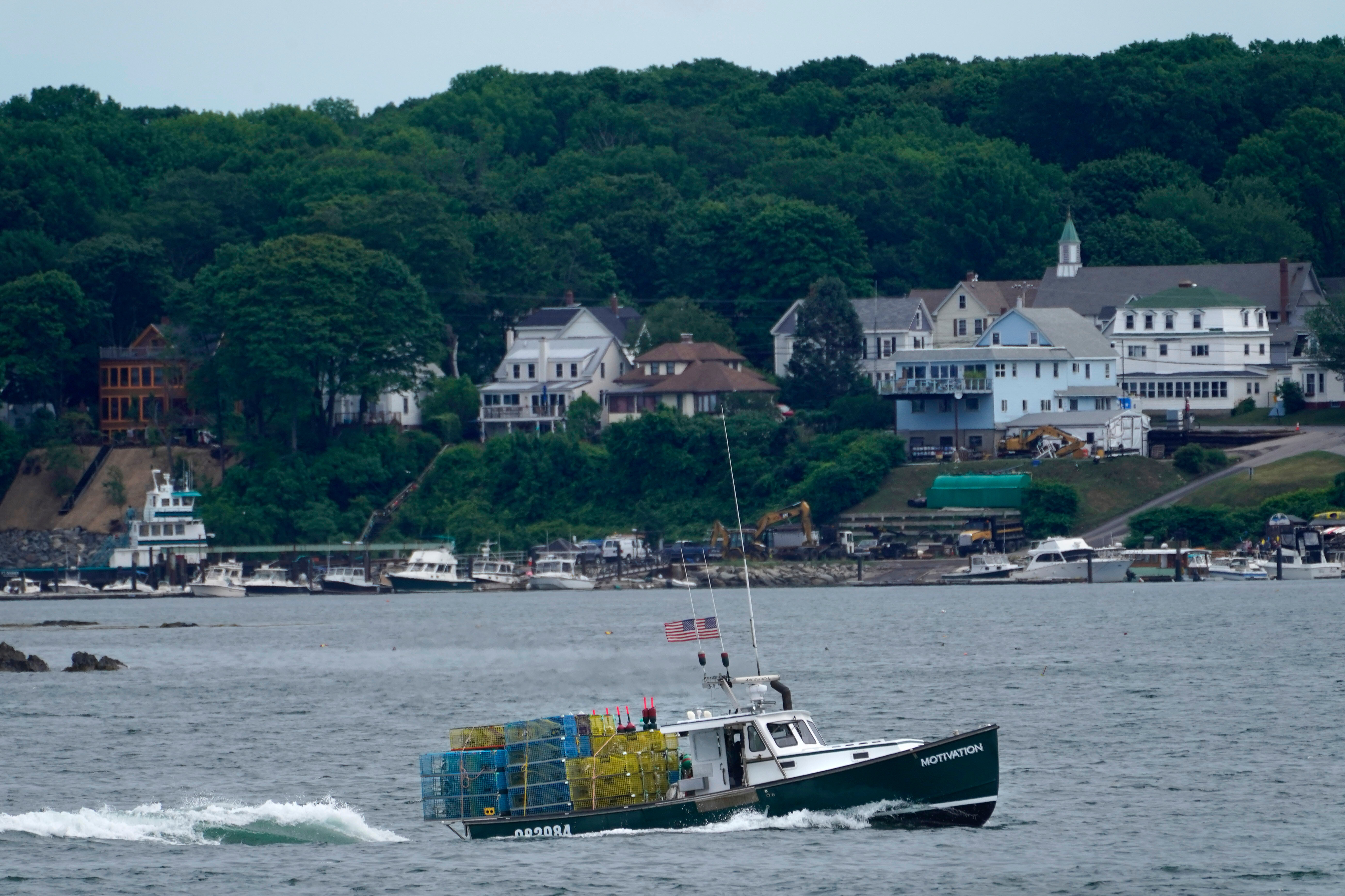 In this July 8, 2021, file photo, a lobster boat carries a heavy load of traps as it motors out to sea near Peaks Island in Portland, Maine.