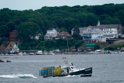 In this July 8, 2021, file photo, a lobster boat carries a heavy load of traps as it motors out to sea near Peaks Island in Portland, Maine.