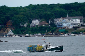 In this July 8, 2021, file photo, a lobster boat carries a heavy load of traps as it motors out to sea near Peaks Island in Portland, Maine.