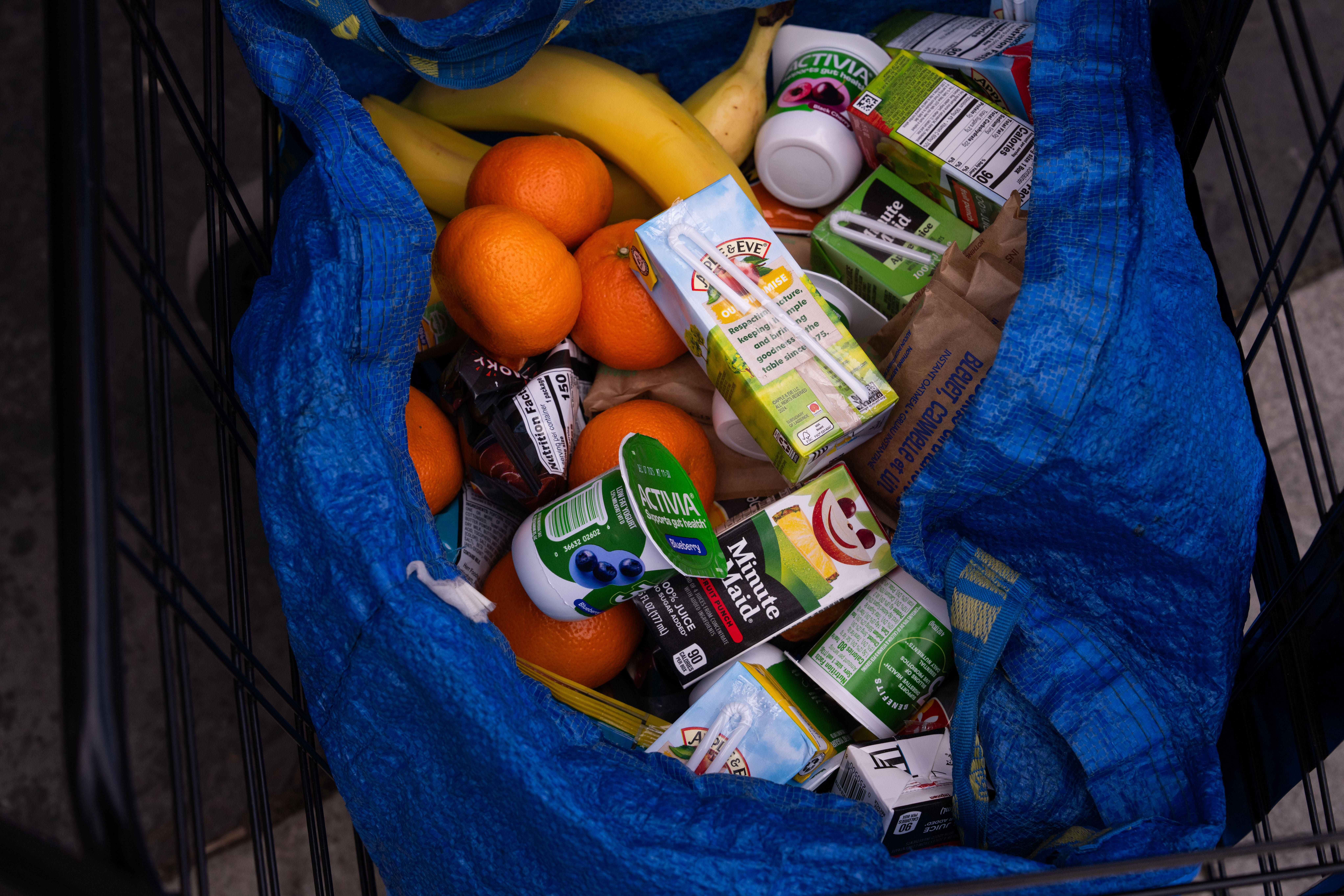 A person stocks their trolley with food from a One Love Community Fridge, Nov. 15, 2025, in Brooklyn, New York.
