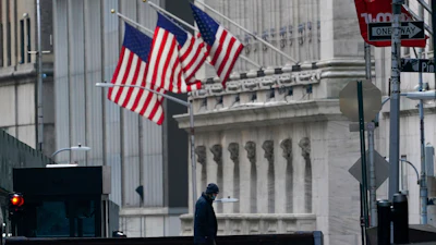 A security guard is seen next to a road block near the New York Stock exchange, Jan. 14, 2022.