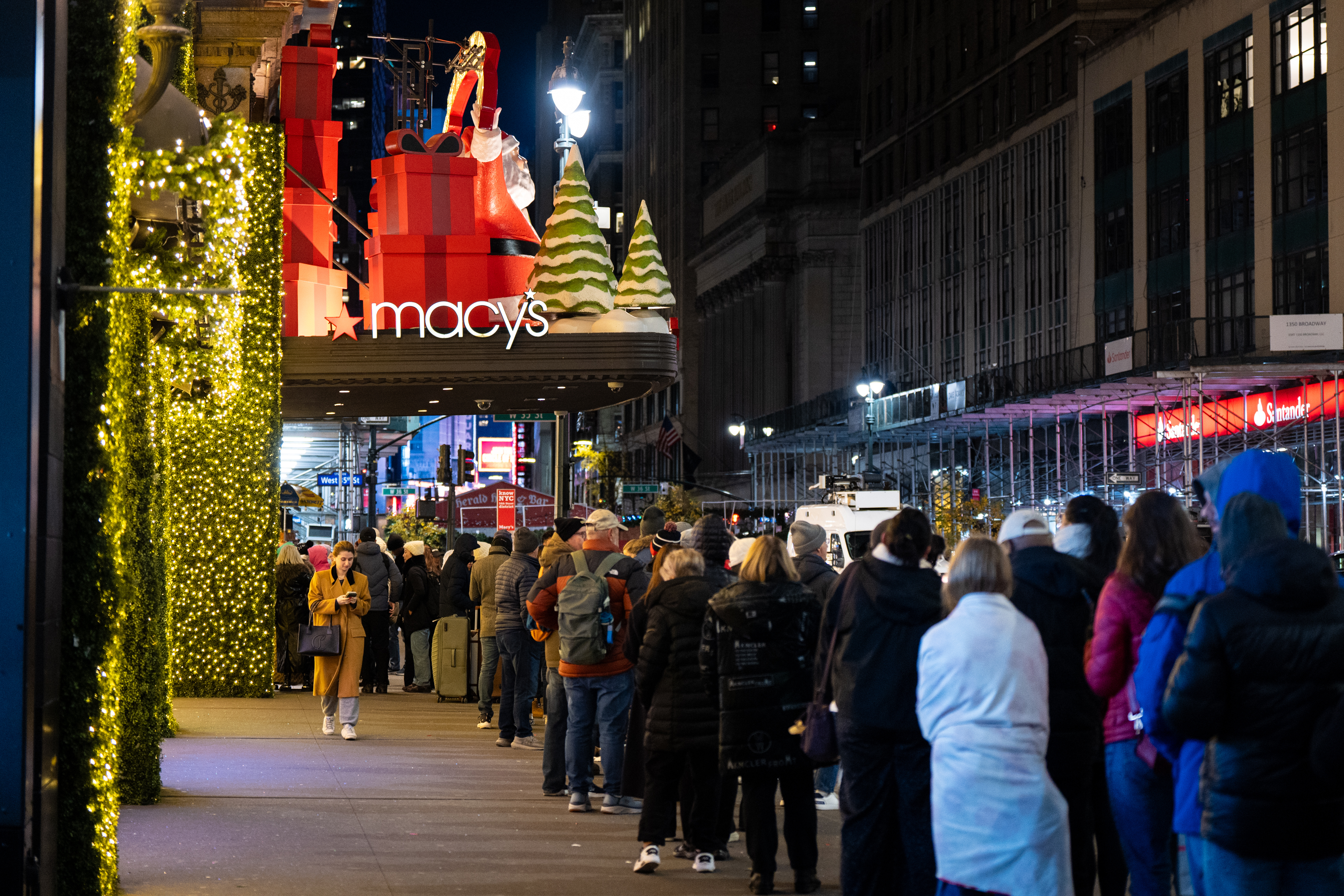 Shoppers wait in line to enter Macy's flagship store on Friday, Nov. 28, 2025.