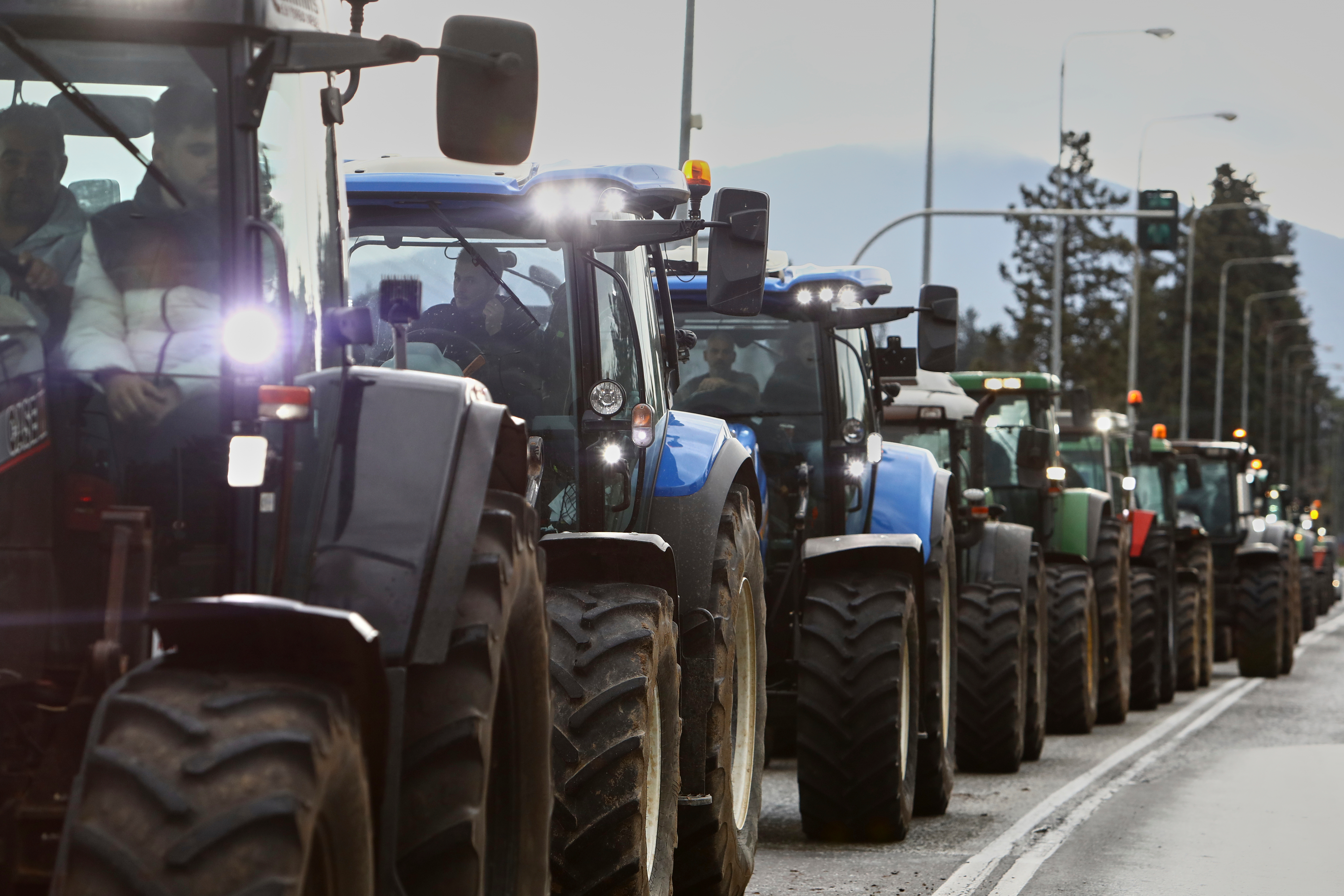 Farmers with their tractors try to block the main access road to Thessaloniki's international airport, Dec. 5, 2025.