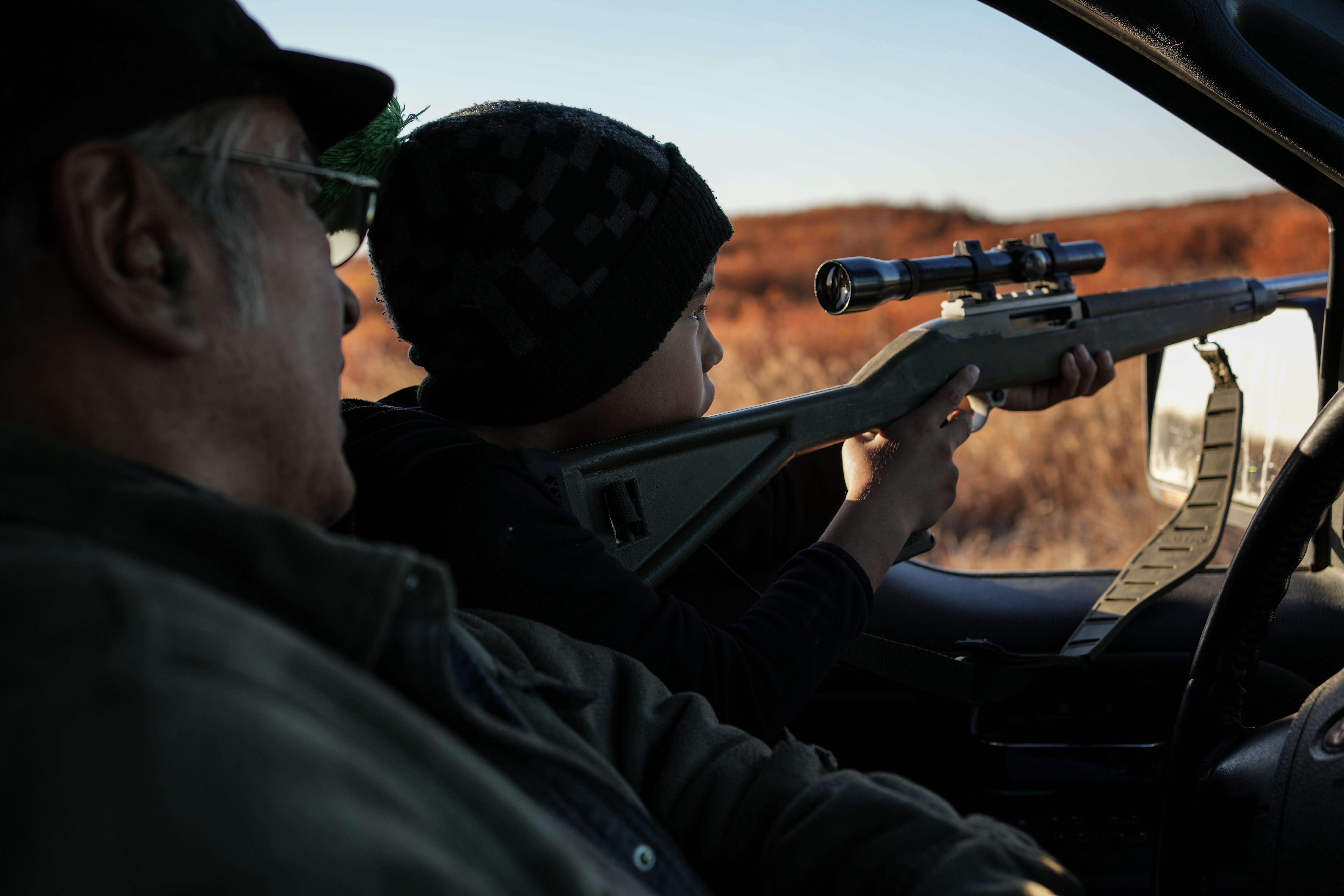 Roswell Schaeffer, an Inupiaq hunter and fisher, helps his great-grandson James Schaeffer, 7, scope ducks while hunting in Kotzebue, Alaska, Friday, Sept. 26, 2025.