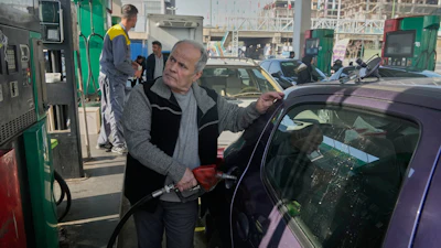 A man fills his car at a gas station in Tehran, Iran, Saturday, Dec. 13, 2025.
