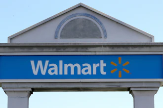 Walmart logo on gray architectural sign against blue sky