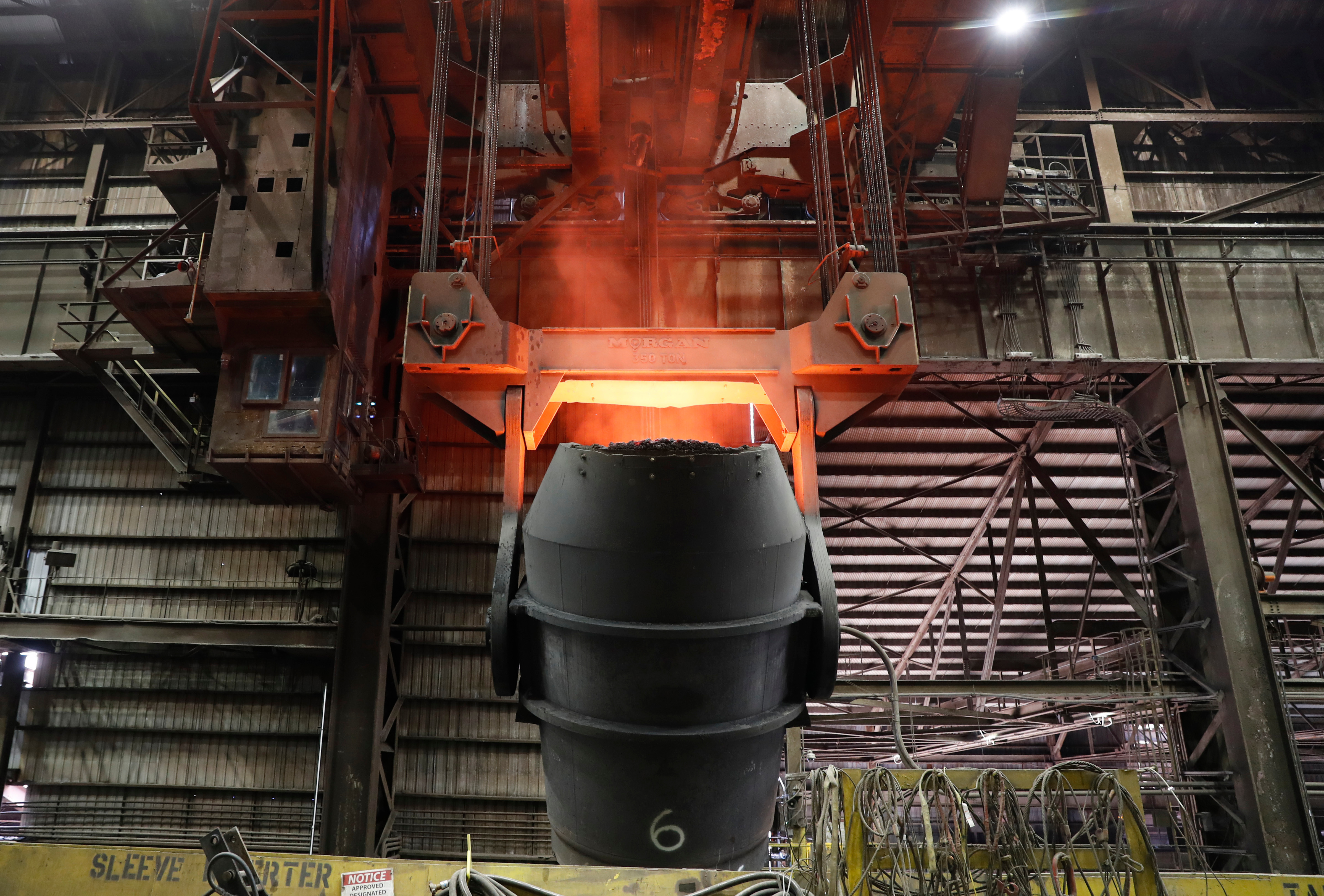 A giant ladle glows red after pouring molten iron in to a vessel inside the basic oxygen furnace as part of the processes of making steel at the U.S. Steel Granite City Works facility Thursday, June 28, 2018, in Granite City, Ill.