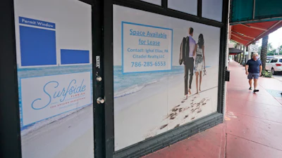 A pedestrian walks past an empty business available for lease, Oct. 12, 2020, Surfside, Fla.