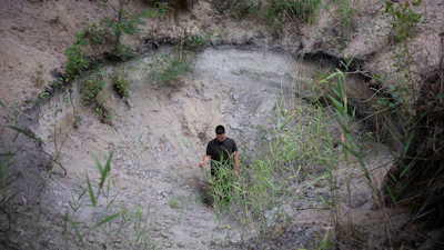 Oszkár Nagyapáti, farmer and member of the volunteer water guardians, stands in a hole in Kiskunmajsa, Hungary, July 29, 2025.