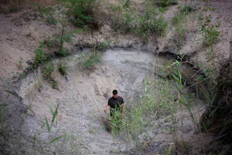 Oszkár Nagyapáti, farmer and member of the volunteer water guardians, stands in a hole in Kiskunmajsa, Hungary, July 29, 2025.