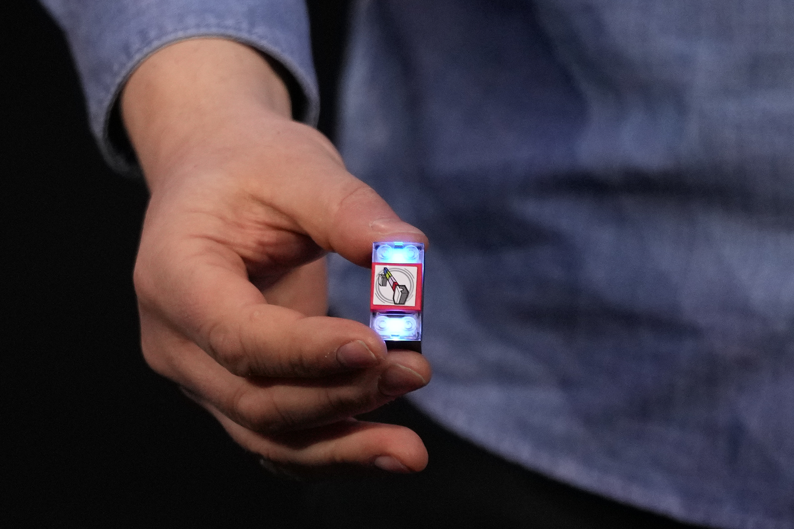 A LEGO smart brick is held during a LEGO news conference ahead of the CES tech show Monday, Jan. 5, 2026, in Las Vegas.