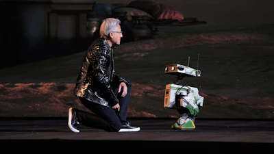 Nvidia founder and CEO Jensen Huang kneels in front of a robot during a Nvidia news conference ahead of the CES tech show Monday, Jan. 5, 2026, in Las Vegas.