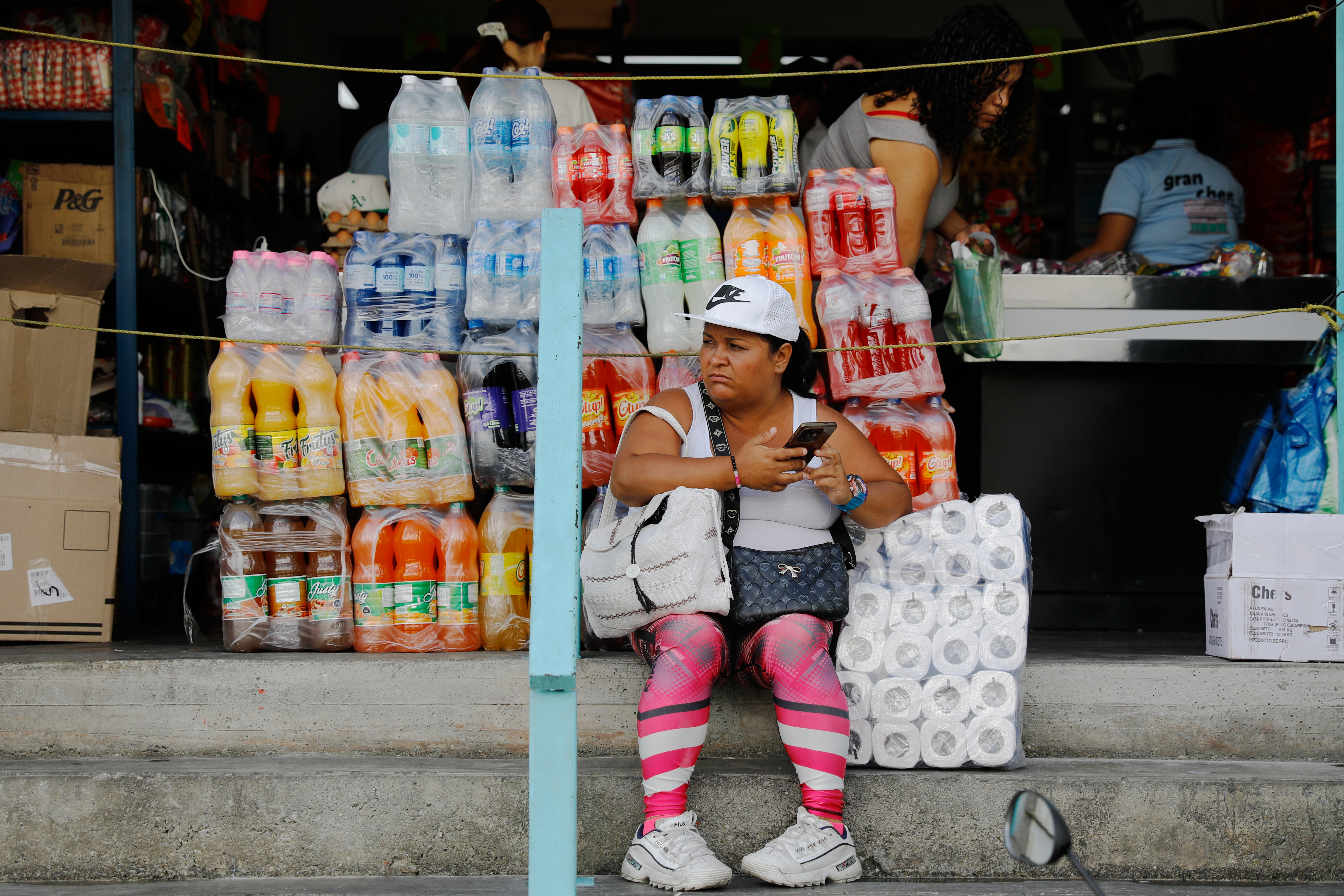 A woman sits in front of a store in the Petare neighborhood of Caracas, Venezuela, Jan. 7, 2026.