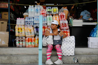 A woman sits in front of a store in the Petare neighborhood of Caracas, Venezuela, Jan. 7, 2026.