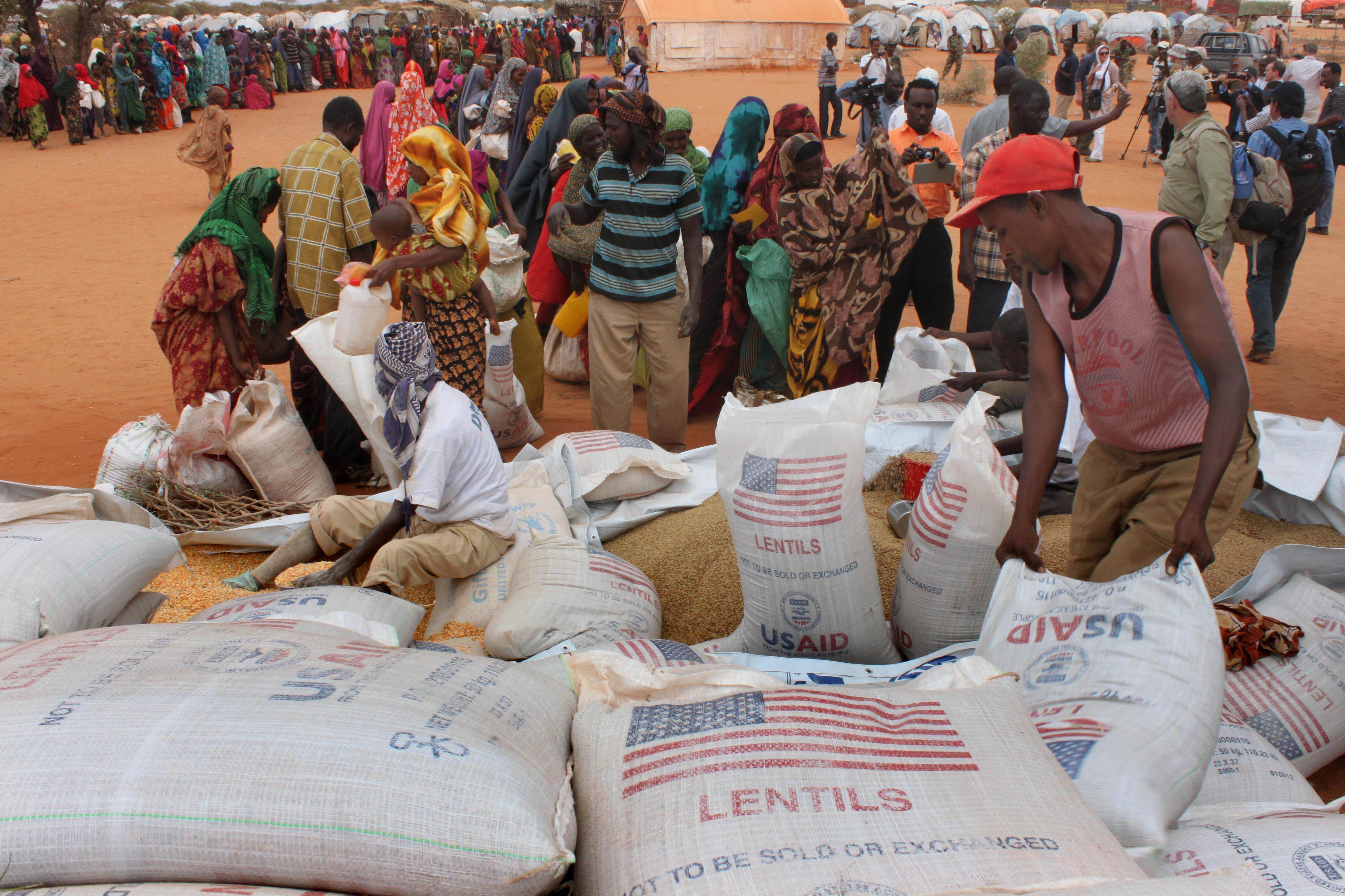 Workers distribute food aid from the World Food Program at a refugee camp in Dolo, Somalia, July 18. 2012.
