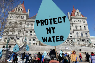 A man carries a sign before a rally opposing the Constitution Pipeline outside the state Capitol in Albany, N.Y., April 5, 2016.