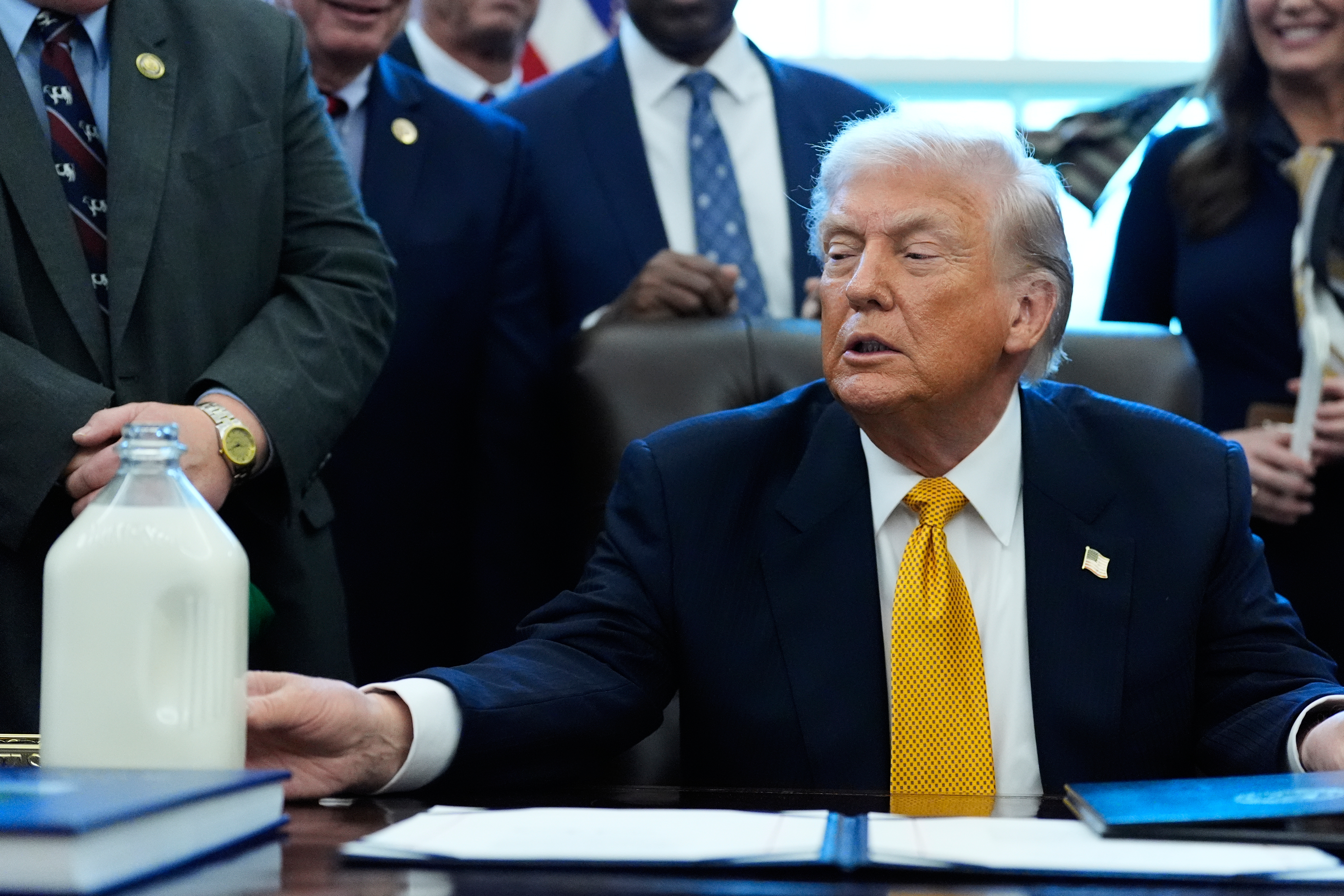 President Donald Trump touches a container of milk in the Oval Office of the White House, Jan. 14, 2026.