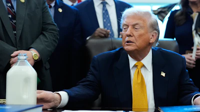 President Donald Trump touches a container of milk in the Oval Office of the White House, Jan. 14, 2026.