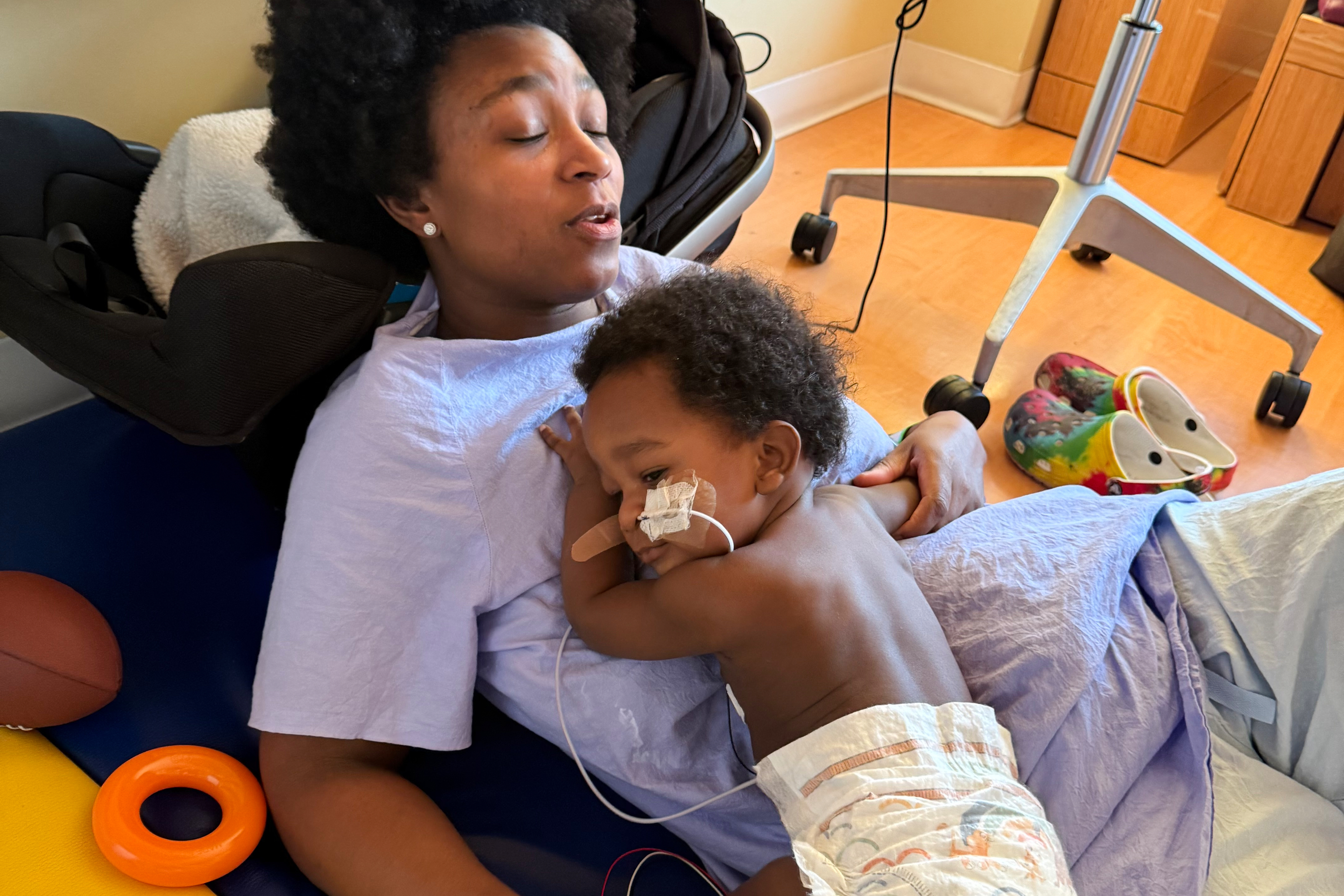 In this photo provided by the family, Ashaan Carter lies on his mother, Angel Carter, at a children's hospital in Portland, Ore., in November 2025.