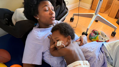 In this photo provided by the family, Ashaan Carter lies on his mother, Angel Carter, at a children's hospital in Portland, Ore., in November 2025.